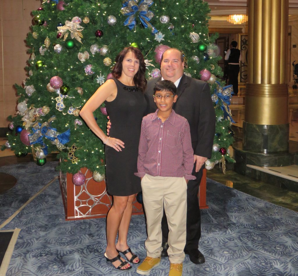 Family standing by Christmas tree