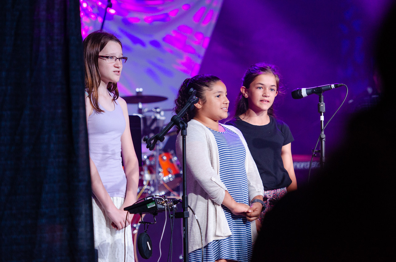 Three Children Singing on Stage