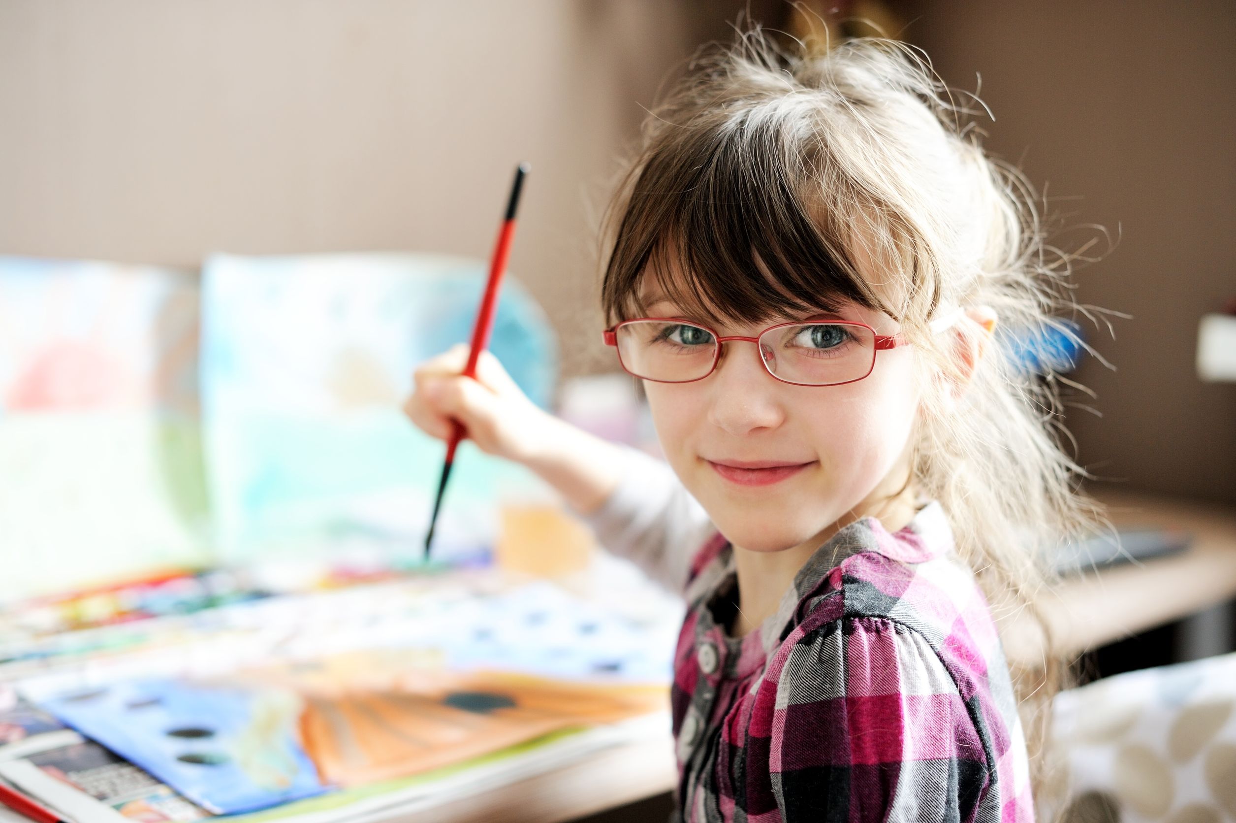 little girl with glasses painting 