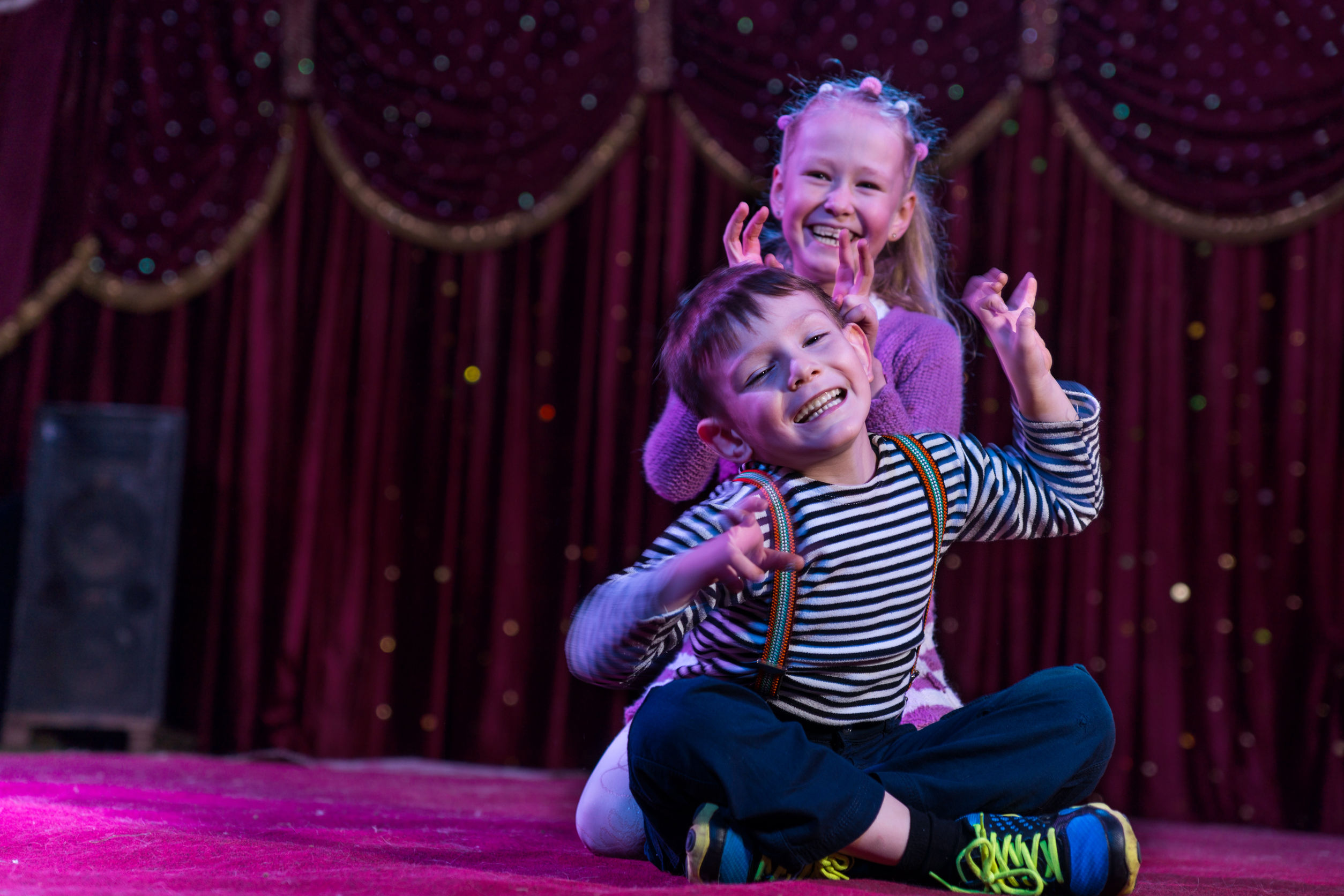 Two funny children acting as monsters on stage